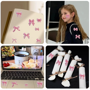Détail de stickers nœuds roses sur ordinateur, papeterie et emballage de cadeau