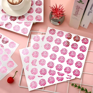 Dettaglio di adesivi decorativi a forma di rosa con finitura metallica su scrivania rosa
