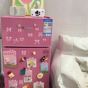 Détail d'autocollants nœuds laser et aimants dessins sur un mini frigo rose