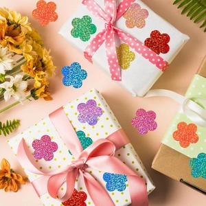 Close-up of glitter flower stickers in assorted colors on gift packaging labels