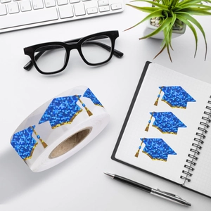 Close-up of blue glitter graduation cap stickers on a roll for festive stationery decor