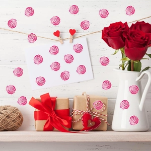 Adesivi decorativi a rosa su pareti di legno bianco, biglietti e brocche di ceramica