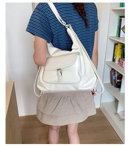 Detail of ivory PU leather tote showing versatile straps and front flap pocket in use