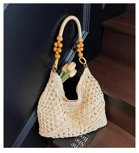 Detail of hand-woven off-white tote bag with decorative brown wooden beads on handle