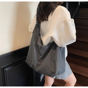 Détail d'un grand sac cabas à carreaux montrant la texture douce du tissu et son drapé