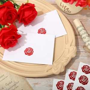 Dettaglio di adesivi decorativi con rose rosse su una busta per chiusura lettere e regali