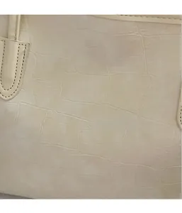 Gros plan sur la texture crocodile beige et les surpiqûres fines du sac fourre-tout