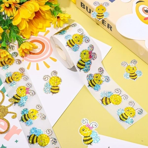 Macro detail of laser holographic bee stickers with glitter finish for gift packaging