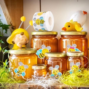 Detail of glitter cartoon bee stickers on honey jars for gift packaging decoration