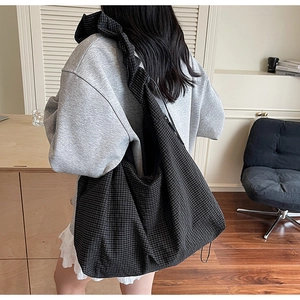 Détail du sac hobo à carreaux noirs avec bandoulière froncée élégante et grande capacité