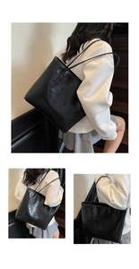 Détail d'un sac cabas noir motif crocodile avec fines bandoulières pour le quotidien