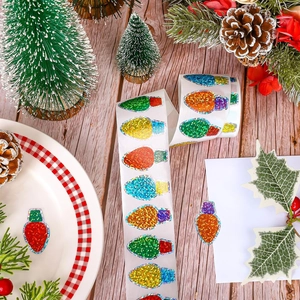 Detail of colorful laser glitter Christmas bulb stickers on a festive wooden desk setting