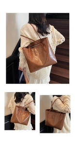 Détail de la texture croco marron sur un grand sac cabas en cuir avec de longues anses