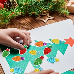 DIY Christmas stickers with glitter light bulb designs on holiday craft paper