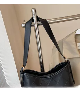 Detail of classic diamond quilted texture and smooth shoulder strap on black tote bag