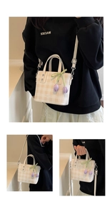 Detail of beige checkered bucket bag with tulip charm and white edge piping accents