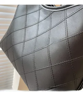 Detail shot of the black quilted rhombic pattern leather and precision stitching on the tote