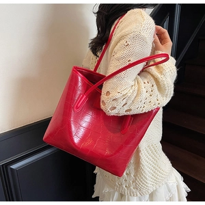 Gros plan d'un sac cabas rouge à motif crocodile avec cuir PU brillant et fines anses