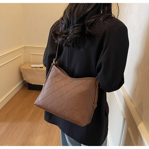 Detail showing the quilted stitch pattern on a dark brown faux leather tote bag