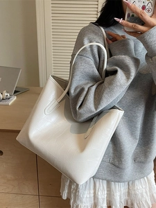 Sac fourre-tout blanc minimaliste avec motif crocodile porté par un mannequin
