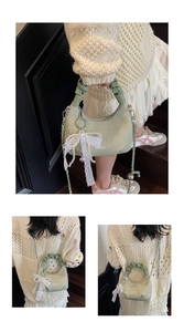Détail du sac coquille tissé vert clair avec poignée plissée et breloque en dentelle perlée