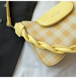 Détail d'un sac bandoulière vichy jaune avec poignée tissée et logo miao & she