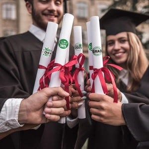 Close-up of Class of 2025 graduation stickers sealing a diploma scroll in a student's hand