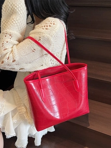 Grand sac cabas rouge avec texture crocodile porté par un mannequin pour le style