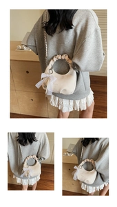 Détail du sac croissant blanc cassé avec nœud en dentelle, breloque perle et bandoulière