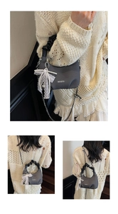 Détail du sac demi-lune gris avec poignée plissée et charm en dentelle et perles