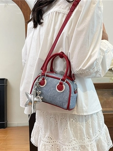Sac bowling en denim bleu avec détails rouges et pendentif étoile sur tenue