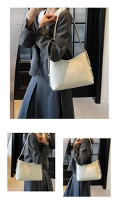 Detail of cream white quilted crossbody bag with adjustable strap and light gold hardware