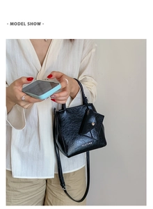 Detailed view of black patent leather mini handbag with Pantour logo and small pouch