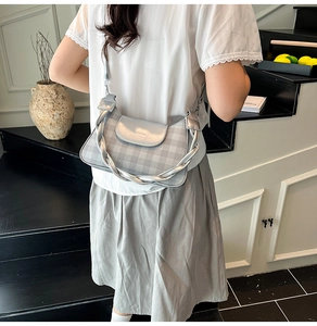 Détail du sac sous l'aisselle argenté à carreaux avec texture métal et chaîne épaisse