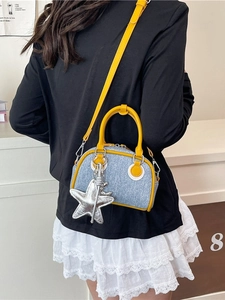 Sac bowling en denim bleu avec finitions en cuir jaune et pendentif étoile sur modèle