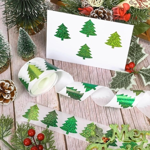 Detailed view of green glitter Christmas tree stickers on a festive gift envelope
