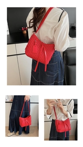 Détails du sac seau rouge tressé montrant la texture, les glands et la bandoulière
