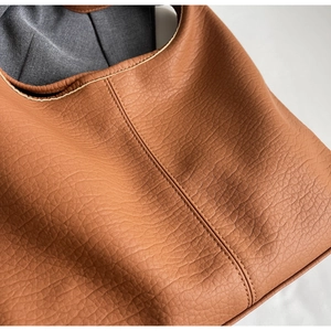 Gros plan détaillé du sac cabas marron en cuir grainé avec coutures de précision