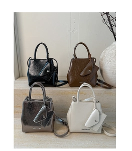 Detail of glossy patent leather handbags in four colors with matching triangle pouches
