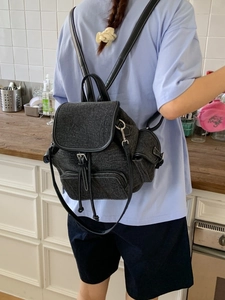 Charcoal canvas backpack with flap drawstring and silver buckles for women shown on model