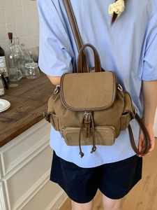 Vintage brown canvas backpack with leather trim and drawstring closure for women