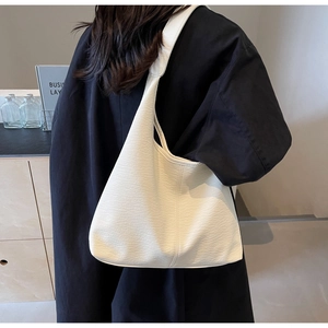 Detailansicht der weißen Leder-Tote-Bag mit Litschistruktur und breitem Schultergurt