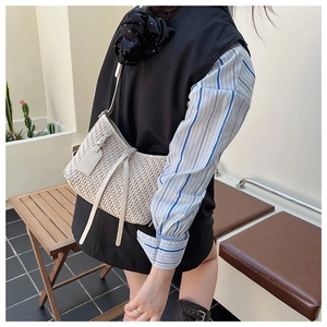 Détail d'un sac bandoulière tissé beige avec des franges et une fine lanière en cuir