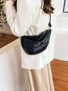 Glossy black crescent dumpling bag with pleated texture and knot shoulder strap detail