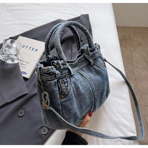 Dettaglio della borsa tote in denim lavato con elementi tasca jeans e rivetti in metallo