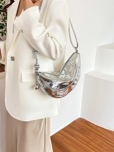 Metallic silver crescent moon bag with knotted strap and ball charm accessory