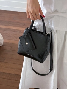 Elegant black matte leather tote bag with silver logo and detachable mini pouch accessory