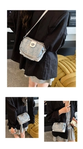 Detailed view of silver star-textured crossbody bag with chunky metal chain and lock