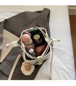 Spacious interior of white bucket bag with drawstring showing storage for daily items