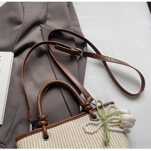 Top view of woven bucket bag with leather trim and pearl tulip charm decoration